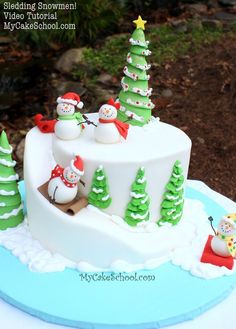 a cake decorated with snowmen and christmas trees