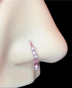 a close up view of a woman's breast with pink and white stones on it