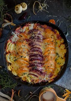 a pan filled with food sitting on top of a table next to utensils