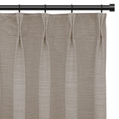 a beige curtain hanging on a metal rod