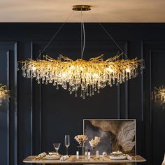 an elegant dining room with black walls and gold chandelier hanging from the ceiling