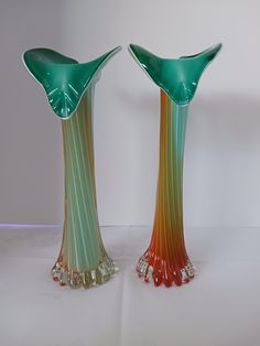 two green and orange vases sitting side by side