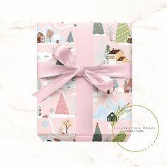 a pink gift box wrapped in paper with a bow on the top and trees around it