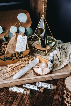 an assortment of candles and other items on a wooden tray next to a candle holder