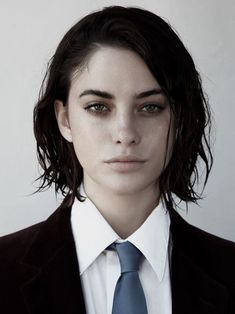 a woman wearing a suit and blue tie