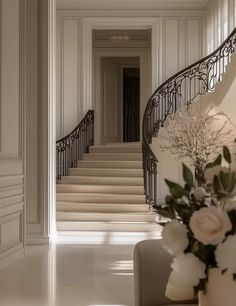 a vase filled with flowers sitting on top of a table next to a stair case