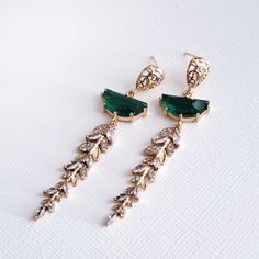 "Gold Emerald Green Earrings for brides, weddings and bridal showers. The perfect gift earrings for bridesmaids, mother of the groom, or mother of the bride. Find earrings for bridal bachelorette party or other special occasions here. A gentle cascade of shimmering gold crystal leaves and Emerald Green crystals in these beautiful nature-inspired bridal earrings. Adding just a hint of sparkle, this pretty pair make gorgeous earrings for both brides and bridesmaids.  Emerald Green glass crystals add a fun pop of color and a great way to sneak in a \"something green\" into your bridal ensemble. Simply stunning!  These beautiful blue statement earrings will complement any bridal style and make the perfect gift for bridesmaids too. The Details: * Made with premium quality crystals * Stones are Green Dress Gold Accessories, Mother Of The Groom Earrings, Statement Earrings Bride, Bride Earrings Gold, Earrings For Bridesmaids, Emerald Art Deco, Emerald Art, Blue Statement Earrings, Emerald Green Earrings