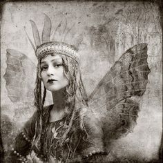 a black and white photo of a woman with long hair wearing a headdress