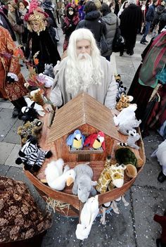 a man with long white hair and beard holding a boat filled with stuffed animals