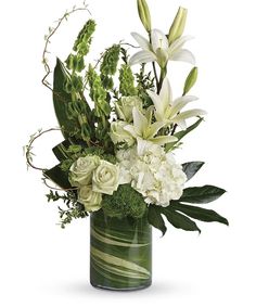 a vase filled with white flowers and greenery