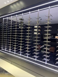 a display case filled with lots of wine bottles next to a wall covered in glass