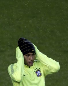 a soccer player is holding his head in the rain