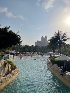 people are swimming in the pool at an amusement park