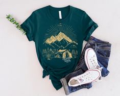 Prepare to embark on a journey of a lifetime with our 'Adventure Awaits' shirt! This shirt is not just a piece of clothing, it's a symbol of endless possibilities and exciting experiences waiting to be discovered. Made with high-quality fabric and featuring a bold and inspiring design, this shirt is perfect for explorers, dreamers, and anyone with a passion for the great outdoors. Whether you're climbing mountains, camping under the stars, or simply seeking new adventures, let this shirt be your companion on the path to new discoveries. Adventure truly awaits, and with this shirt, you'll be ready to embrace it every step of the way. Unisex Jersey Short Sleeve Tee Bella+Canvas 3001 This classic unisex jersey short sleeve tee fits like a well-loved favorite. Soft cotton and quality print mak Green Summer Adventure Top, Summer Adventure Short Sleeve Shirt, Summer Green Top For Camping, Green Summer Top For Camping, Pre-shrunk Graphic Tee For Adventure, Pre-shrunk Summer Adventure Shirt, Pre-shrunk Summer Shirt For Adventure, Pre-shrunk Relaxed Fit Adventure Shirt, Pre-shrunk Relaxed Fit Shirt For Adventure