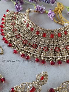 This Jodha style ruby red semi-bridal set consists of a statement necklace, earrings and tikka. Necklace plating is antique gold. Sparkling champagne stones with superior craftsmanship. Perfect for Indian and Pakistani weddings. Product Details: * Necklace -  Comes with adjustable zari cord.  * Earrings - For pierced ears. Length: 7 cm, Width: 4 cm, Weight: 19 gm approx * Maang Tikka Buy bridal bangles, chuda / choora and kalira here: https://www.etsy.com/shop/VelikayaCollection?section_id=30852312 Check out our collection of nose-rings, pasa, haathphool and hair accessories: https://www.etsy.com/ca/shop/VelikayaCollection ----------- CARE ----------- - Store in air tight zip lock bags - Do not expose to moisture/water - Do not spray chemicals or perfumes on the jewelry Please feel free to Heavy Red Lehenga For Diwali, Heavy Red Lehenga For Reception, Festive Heavy Red Lehenga, Red Heavy Lehenga For Wedding, Heavy Red Wedding Sets, Red Ruby Bridal Necklace For Reception, Red Meenakari Jewelry For Reception, Traditional Red Jewelry For Reception, Red Chandbali Earrings With Zari Work