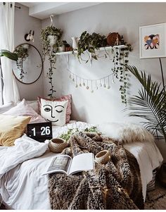 a bed room with a neatly made bed and plants on the headboard, along with books