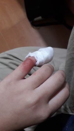 a person with bandages on their fingers holding something