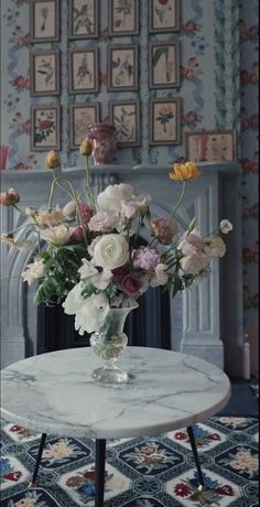 a vase filled with flowers sitting on top of a table next to a fire place