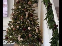 a decorated christmas tree sitting on top of a stair case next to a banister