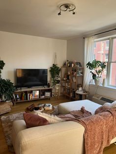 a living room filled with furniture and a flat screen tv sitting on top of a wooden floor