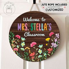 a wooden sign that says welcome to mrs stella's classroom with flowers on it