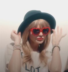 a woman wearing heart shaped sunglasses and a hat