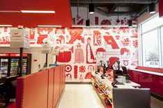 the interior of a store with red and white wallpaper