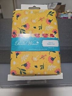 the package is yellow with pink and blue flowers on it's front, and has a