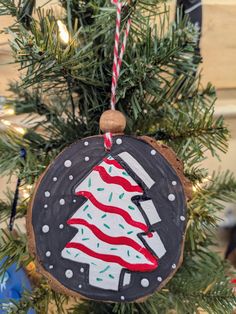 a christmas ornament hanging from a tree with an american flag painted on it