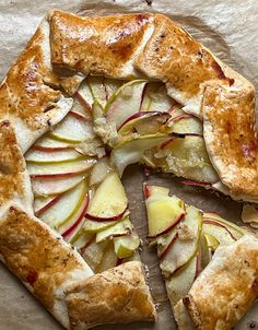 an apple pie with one slice cut out and ready to be eaten on a piece of parchment paper