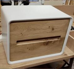 a white and wood cabinet sitting on top of a wooden table