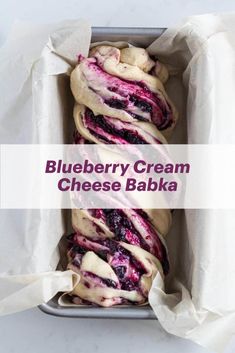 blueberry cream cheese bake in a metal pan with white paper on the side