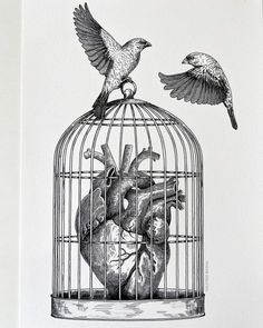 two birds are perched on top of a heart in a birdcage that is hanging from the ceiling