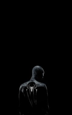 a person standing in the dark wearing a hoodie