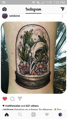 a tattoo on the leg of a person with flowers in a glass dome and stars