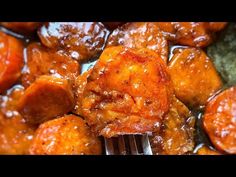 a close up of food on a fork in a pan with sauce and meatballs