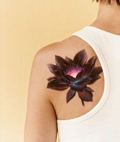 the back of a woman's white tank top with a purple flower on it