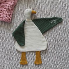 two knitted ducks are laying on the floor next to each other and one is wearing a sweater