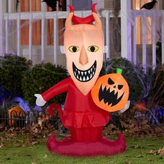 an inflatable statue of a devil holding a jack - o - lantern