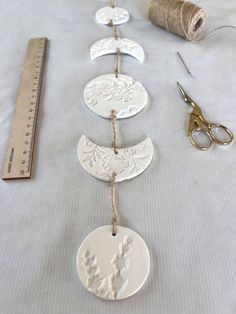 several ornaments are laid out on a table with scissors, thread and spools