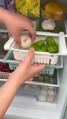 a person reaching for some food in an open refrigerator