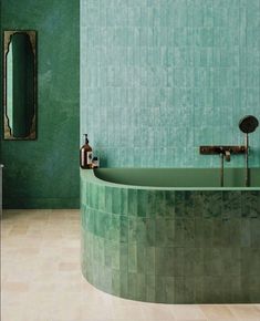 a bathroom with green walls and tile flooring is pictured in this image, there is a bathtub next to the sink