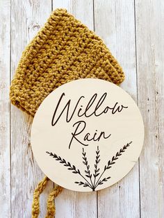 a wooden sign that says willow run on it next to a crocheted hat