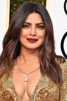 an image of a woman with long hair wearing a gold dress and lipstick on the red carpet