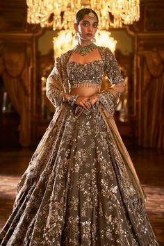 This lehenga set features intricate embroidery in sequin, bead and crystal in antique tones on a coffee brown tissue silk base. The elbow sleeve blouse has tassels at sleeve hem and is paired with a contrasting antique gold tissue dupatta with matching heavy embroidery.From Seema Gujral's Falaknuma collection. DELIVERY TIMEPlease allow 8-12 weeks for your outfit to arrive. FABRIC DETAILSLehenga & Blouse - Tissue Silk Dupatta - Tissue organza Professional cleaning only.