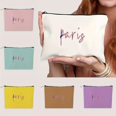 a woman holding a purse with the word paris written on it in multiple different colors