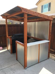 an outdoor hot tub in the middle of a yard with a wooden pergolan roof