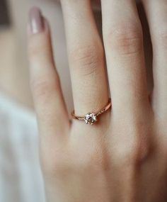 a woman's hand with a diamond ring on it