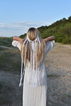 a woman with her back to the camera wearing a white dress and tassels