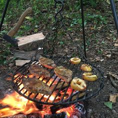 hamburgers and donuts are cooking over an open fire in the woods on a grill